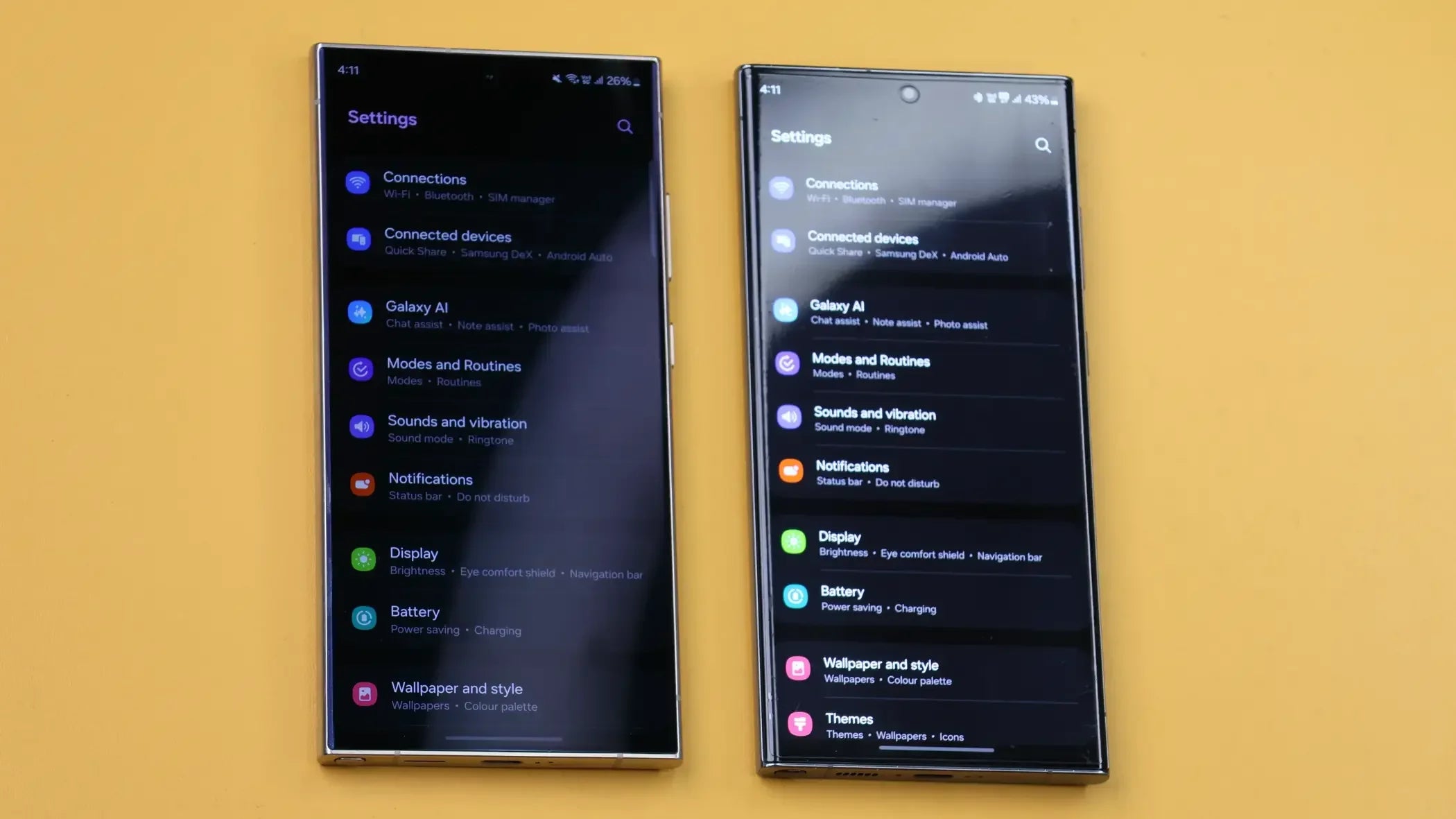 Two Samsung smartphones side by side displaying settings menu on yellow background
